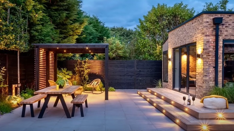 Backyard makeover with awning, patio table, and outdoor lights