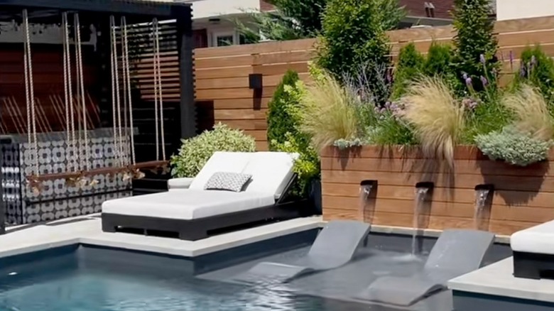 Pool with lounge chairs and greenery
