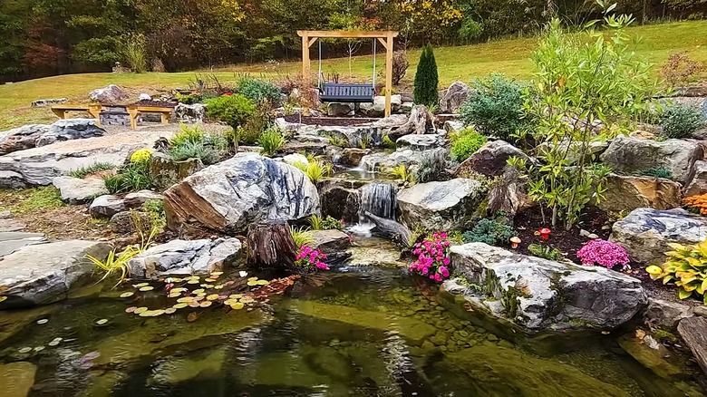 Rocks with a pond surrounded by flowers and plants