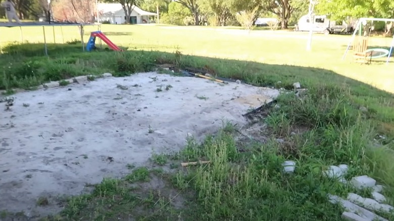 Slab of concrete with overgrown grass