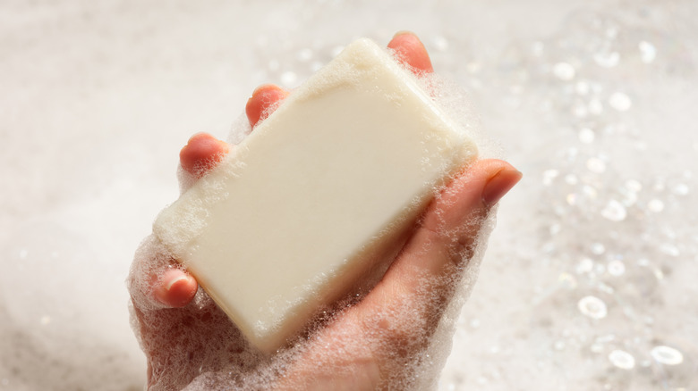 Close up of person holding foamy bath soap in their hand