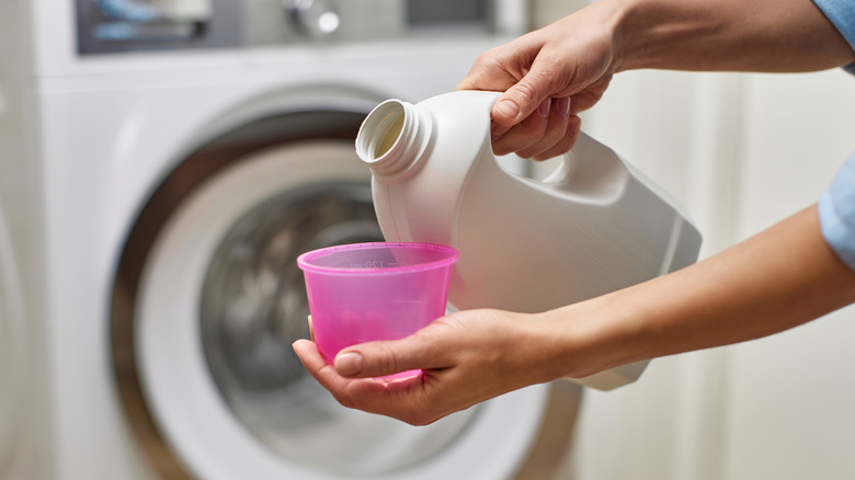 Close up of person pouring laundry detergent