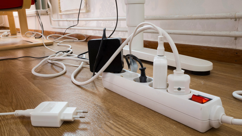 Close up of white power strip with multiple outlets plugged in
