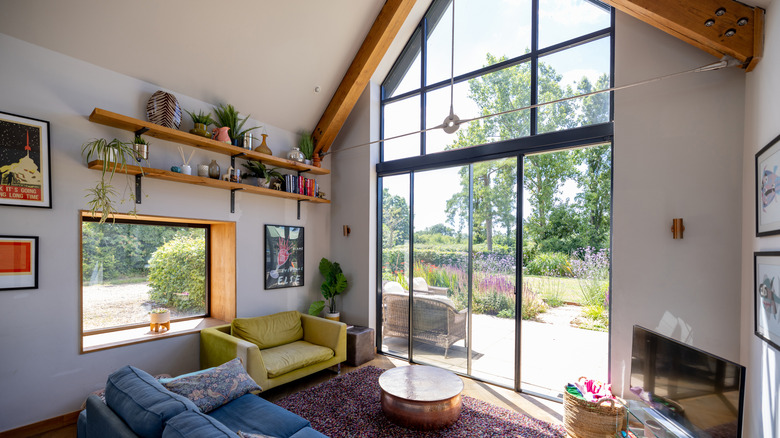 Living room with floating shelves and a vaulted ceiling