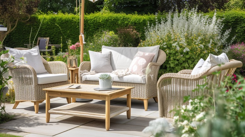 Patio set with umbrella and coffee table on slate in a yard