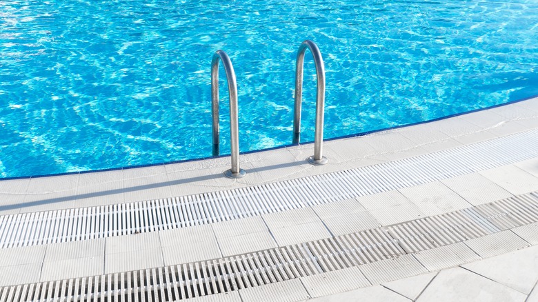 Side of a pool with brilliant blue water