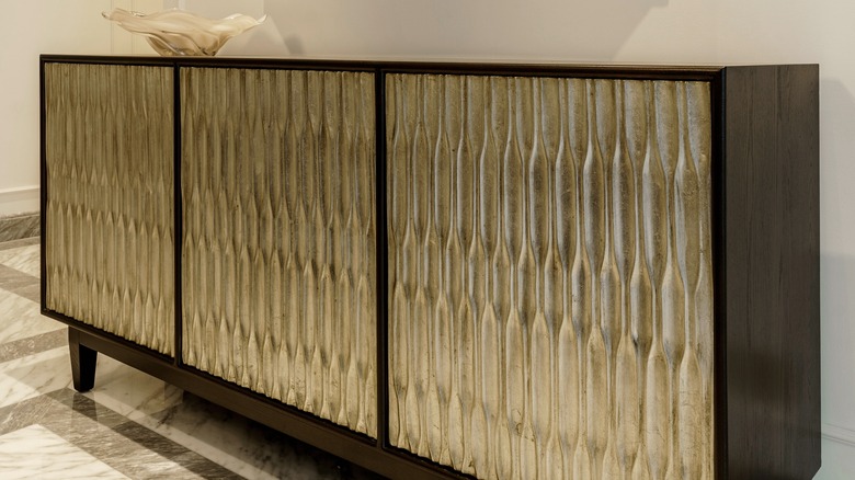 A sideboard with an opaque glass cover holding a white catch-all dish