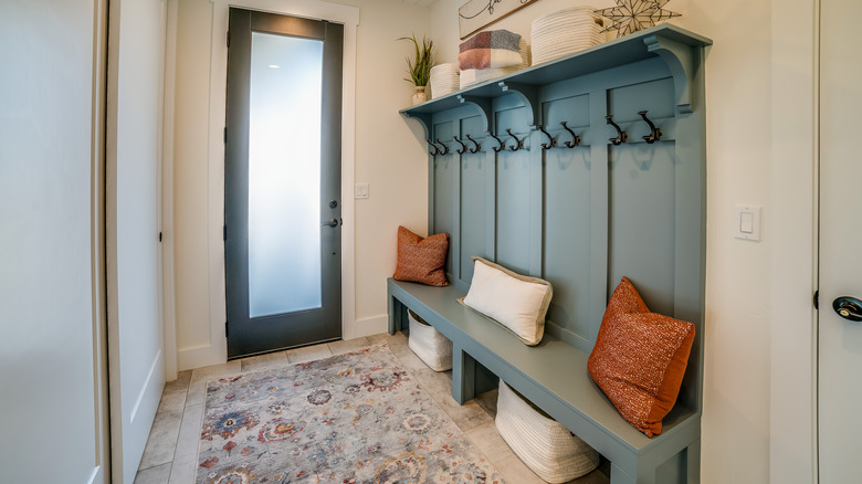 An entryway with seating space and storage baskets underneath