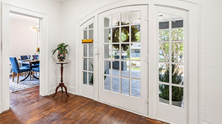 A minimal style entryway with a vase on a side table