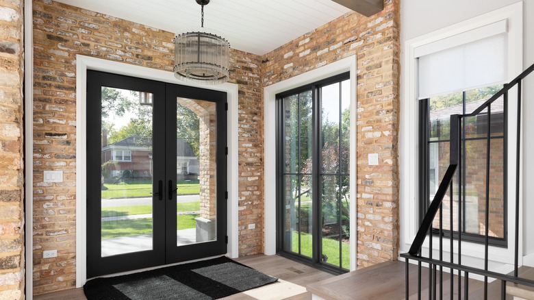 An exposed brick entryway with a hanging pendant light