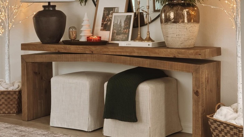 White stools beneath a wood console table