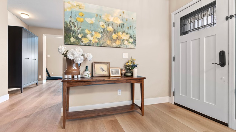 A spacious entryway with wood console table and pretty artwork