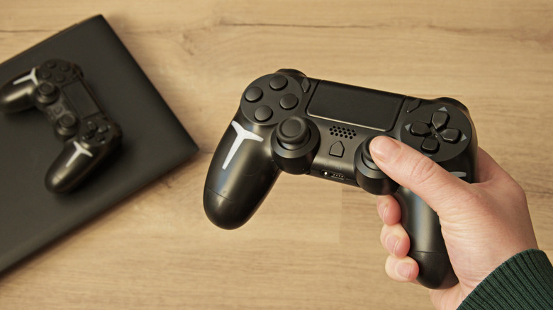 Person holding black video game controller