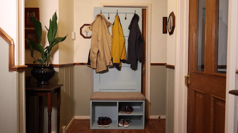an old door turned into a hallway tree for universal entry and shoe storage
