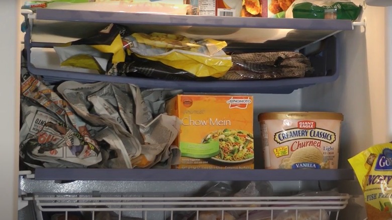 Crumpled up newspaper on refrigerator shelf.