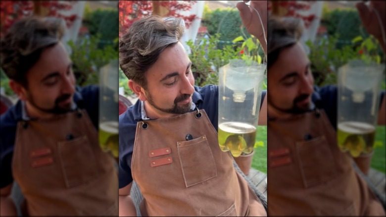 a man makes a hanging wasp trap from a plastic bottle