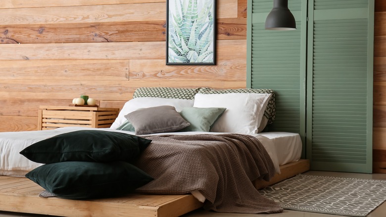stacked green pillows near bed