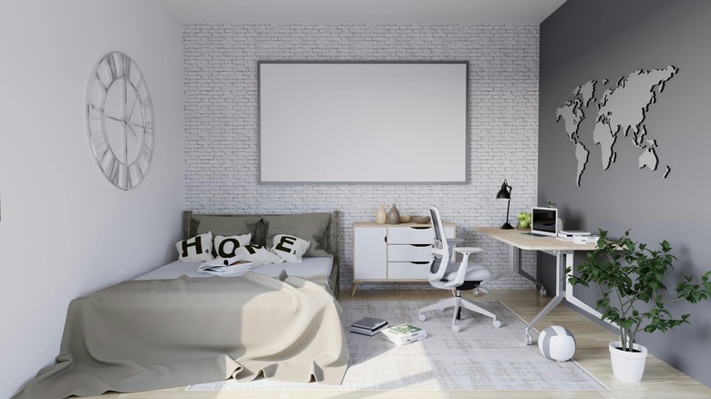 gray and white bedroom with brick accent wall and wall art