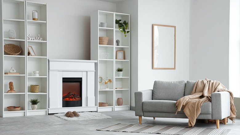 fireplace feature wall next to two white bookshelves with decor on them