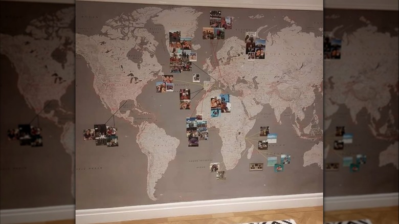 map accent wall of the world with vacation photos on it