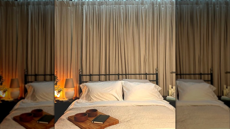 curtain accent wall behind bed with tray on top