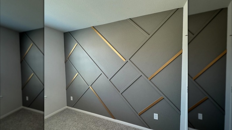dark gray accent wall with geometric shapes and gold accents