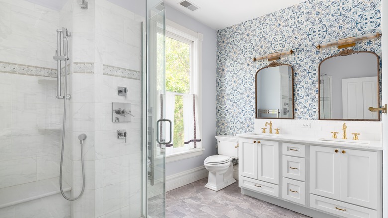 white bathroom with fun print tile behind toilet and vanity