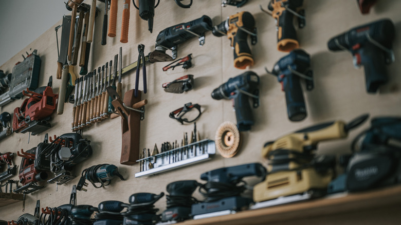 A collection of hand tools hung up on the wall