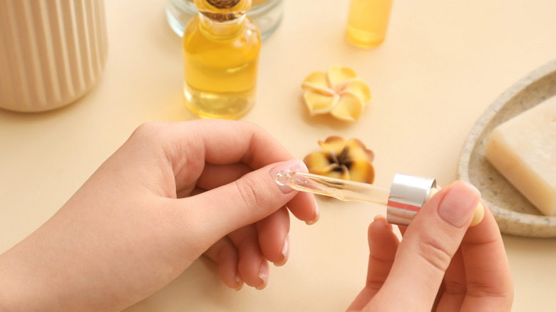 Someone applying cuticle oil to their fingernail