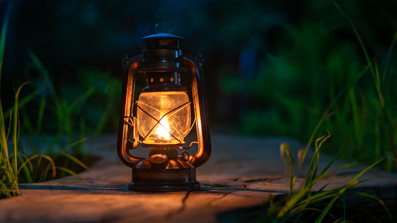 An antique oil lamp outside at night.
