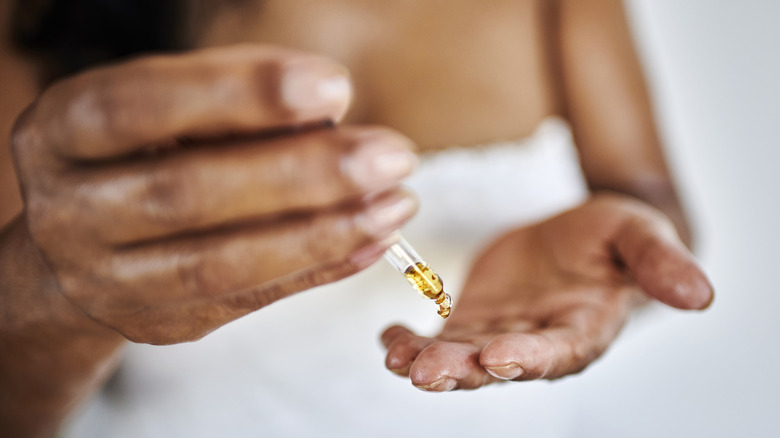 Someone moisturizing their hands with oil