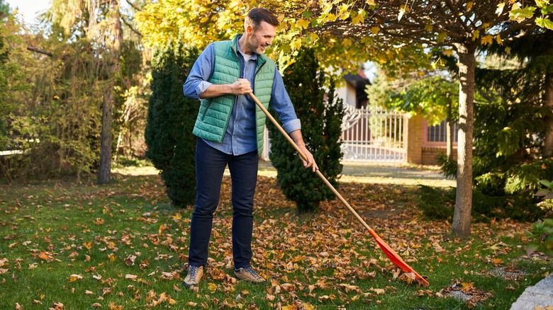 man raking his yard