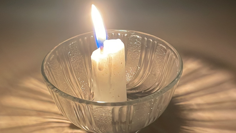 small glass bowl with lit white candle