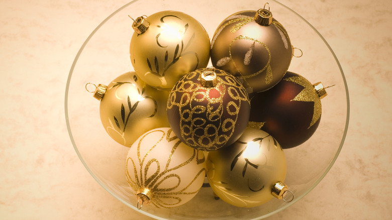Gold glittery Christmas ornaments in glass bowl