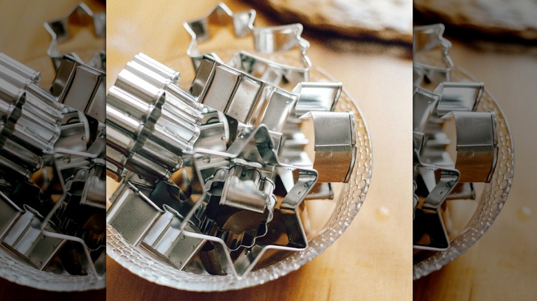 glass bowl with different silver cookie cutters on table