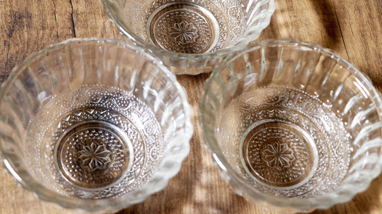 Three decorative salad glass bowls on wooden surface