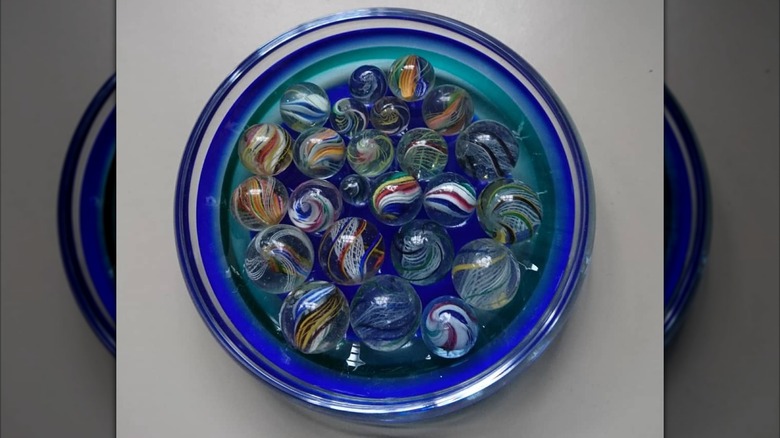 glass bowl with blue tints filled with marbles
