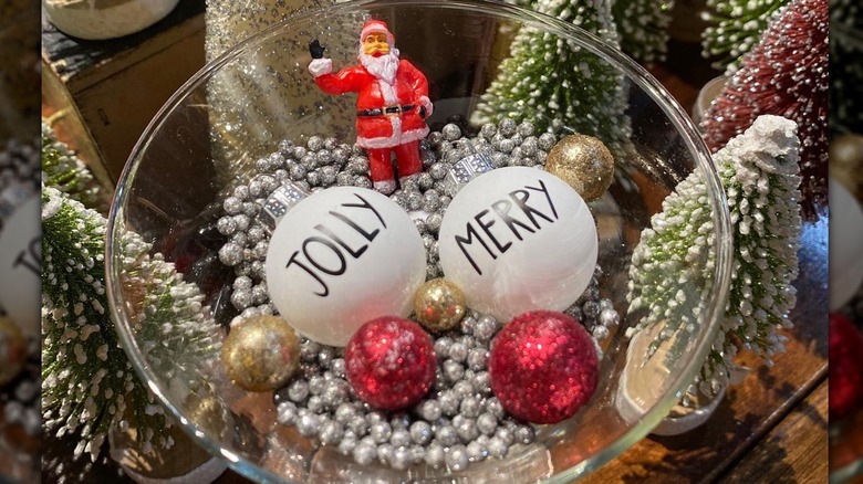glass bowl with ornaments, holiday figurines, and silver beads