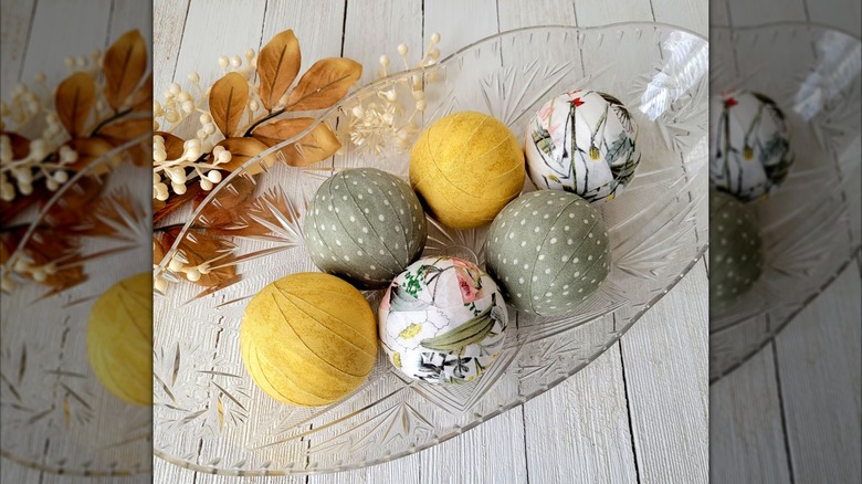 long glass bowl with green, yellow, and floral rag balls