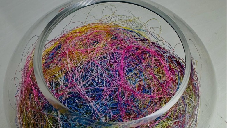 colorful pieces of thread inside glass bowl