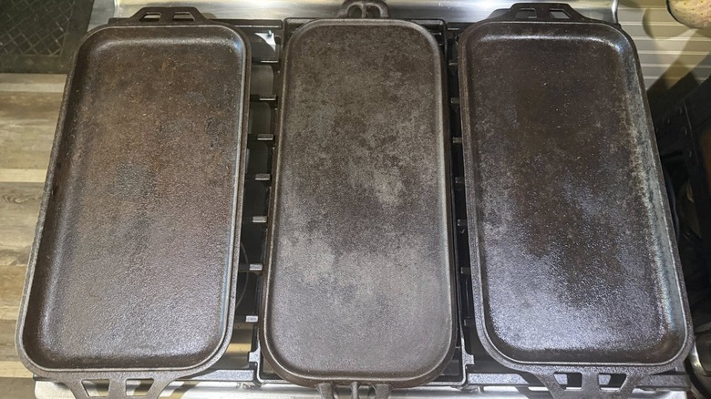 Three cast iron griddles on gas stovetop