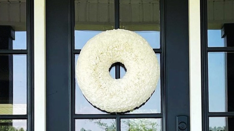 A coffee filter wreath on a black-framed glass door.