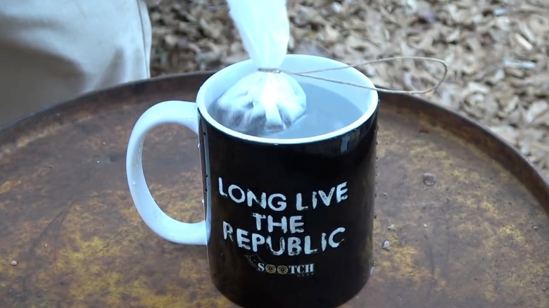 A mug with a coffee filter tea bag in it.