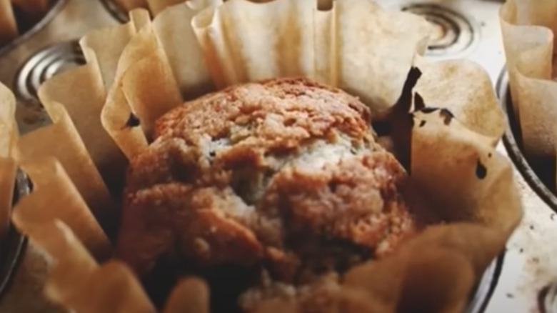 Close up of muffin with coffee filter liner in tin.