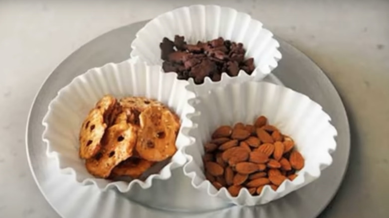 Three coffee filter bowls holding dry snacks.
