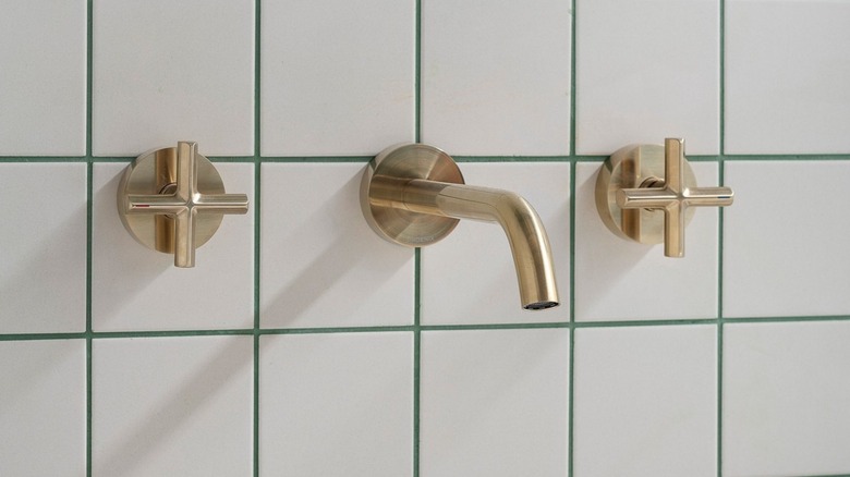 White tile with green grout and gold hardware