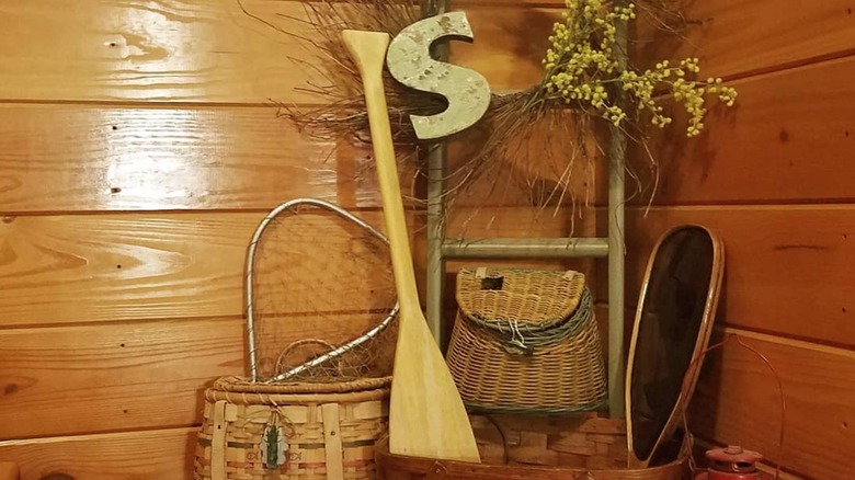 Paddle, woven baskets, wreath, and ladder on a staircase landing