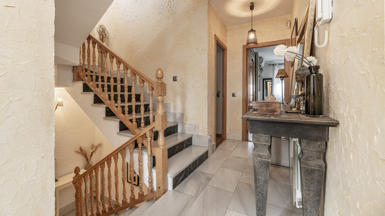 A staircase landing with a table holding decor items