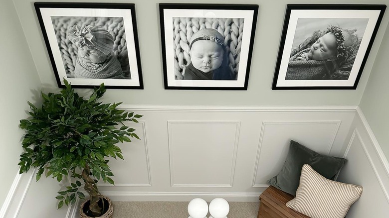 Baby pictures, plant, and cushions on a staircase landing