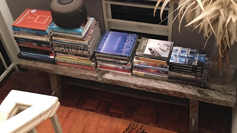 A long table laden with books at staircase landing
